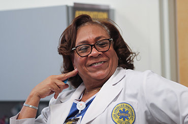 Woman wearing a jacket with a Los Angeles Southwest Nursing College patch smiling
